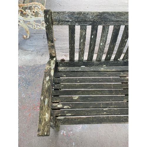 217 - A teak two seater garden bench - approx. 96cm high x 139cm wide x 51cm deep