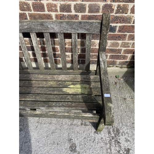 220 - A teak three seater garden bench - approx. 92cm high x 184cm wide x 64cm deep