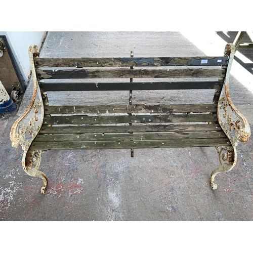 221 - A Victorian style cast iron and wooden slatted garden bench - approx. 83cm high x 126cm wide x 79cm ... 