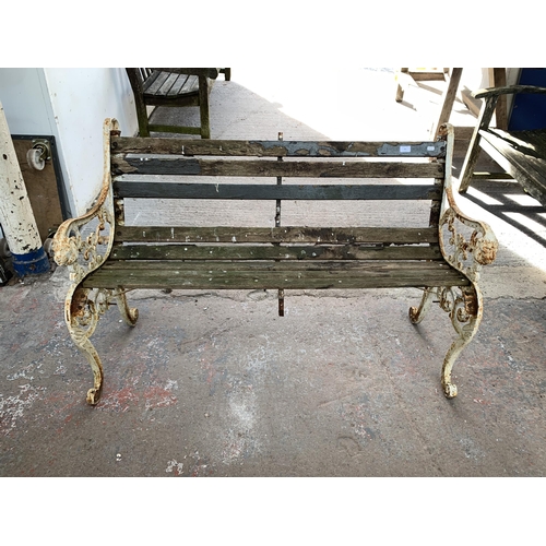 221 - A Victorian style cast iron and wooden slatted garden bench - approx. 83cm high x 126cm wide x 79cm ... 