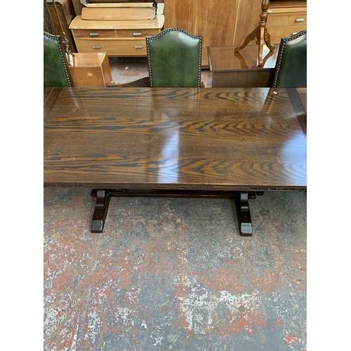 229 - A Jaycee carved oak draw leaf dining table on baluster supports and eight green leather upholstered ... 