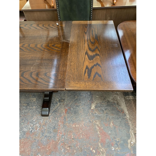 229 - A Jaycee carved oak draw leaf dining table on baluster supports and eight green leather upholstered ... 