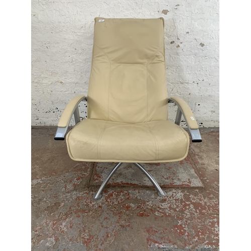 246 - A modern cream leather and grey metal swivel reclining armchair and footstool