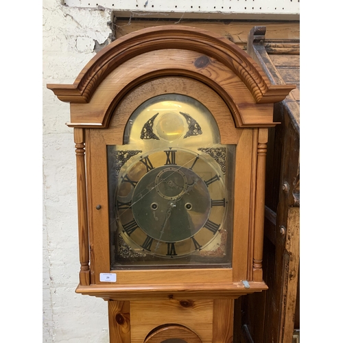 29 - A pine cased grandfather clock with brass face - approx. 195cm high