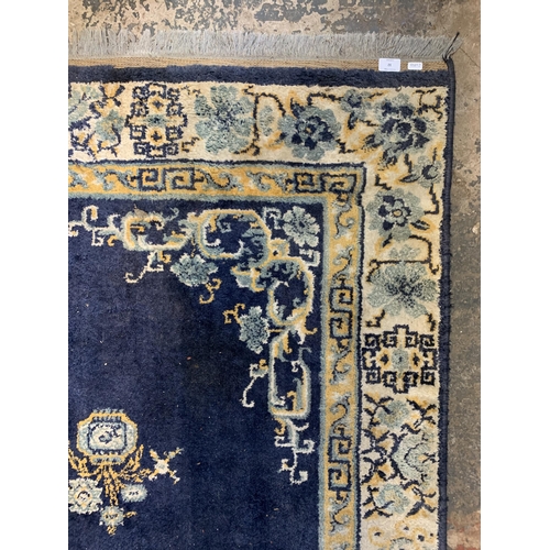 32 - A late 20th century blue floral pattern rug - approx. 280cm x 190cm