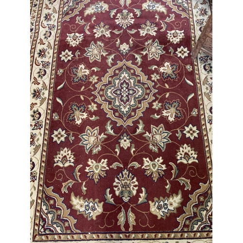 33 - A late 20th century red floral pattern rug - approx. 292cm x 200cm