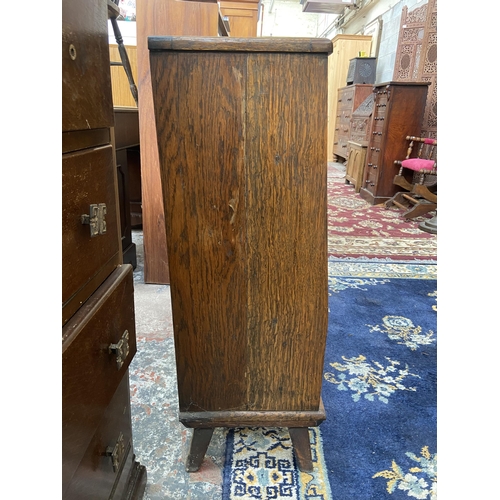 48 - A mid 20th century carved oak bookcase with two glass sliding doors and fall front - approx. 88cm hi... 