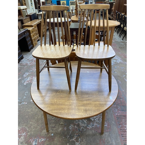 94 - A mid 20th century Dinette teak effect and beech circular drop leaf dining table and two Ercol style... 