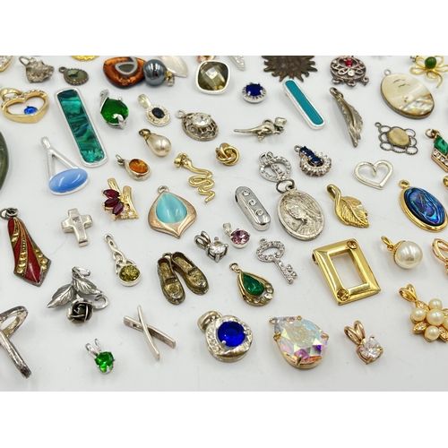 2063 - A collection of pendants to include abalone, mother of pearl, white metal etc.