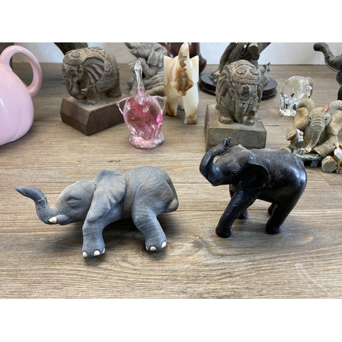 334 - Twenty elephant figurines to include resin, Langham Glass, onyx, carved teak etc. - largest approx. ... 