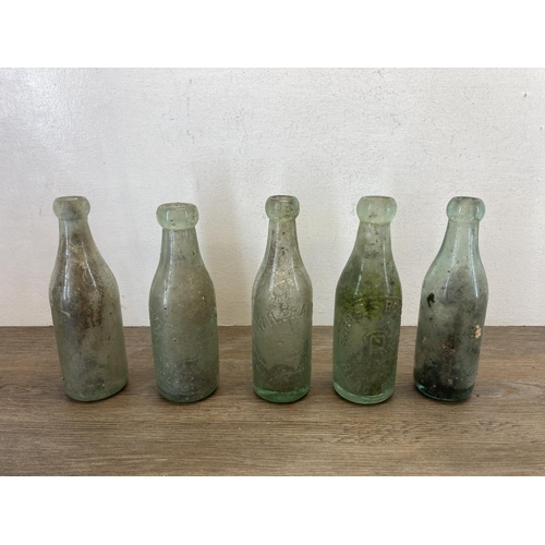 336 - Eleven items, ten early 20th century glass bottles and one stoneware twin handled jar