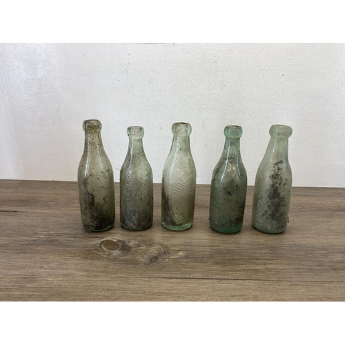 336 - Eleven items, ten early 20th century glass bottles and one stoneware twin handled jar