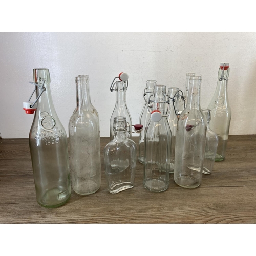 366 - A collection of glass bottles and demijohns together with wood and metal wine press - approx. 48cm h... 