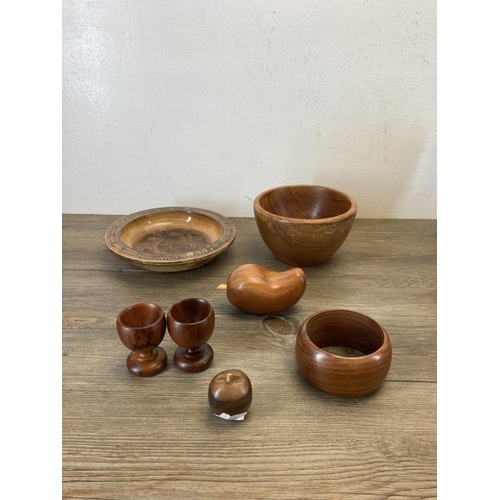 369 - A collection of treenware to include teak bowls, carved elephant figurines etc.