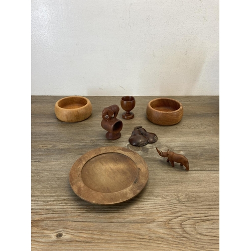 369 - A collection of treenware to include teak bowls, carved elephant figurines etc.