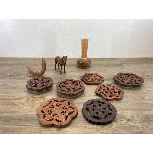 369 - A collection of treenware to include teak bowls, carved elephant figurines etc.