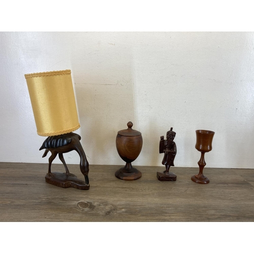 371 - A collection of treenware to include carved stork table lamp, elephant figurines, model boat etc.