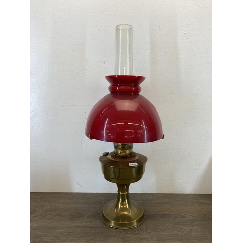 375 - A collection of items to include Aladdin No. 23 brass oil lamp with red glass shade, brass ornaments... 