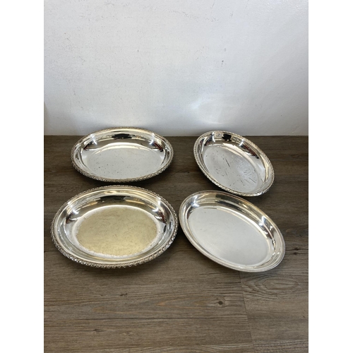 381A - A collection of metalware to include brass candlesticks, silver plated oval trays etc.