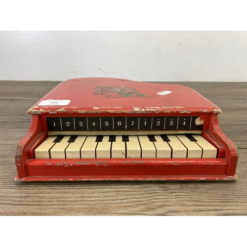 393 - Two mid 20th century toys, one piano and one St. Michael cash register - approx. 19cm high