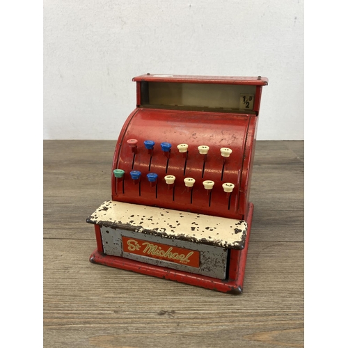 393 - Two mid 20th century toys, one piano and one St. Michael cash register - approx. 19cm high