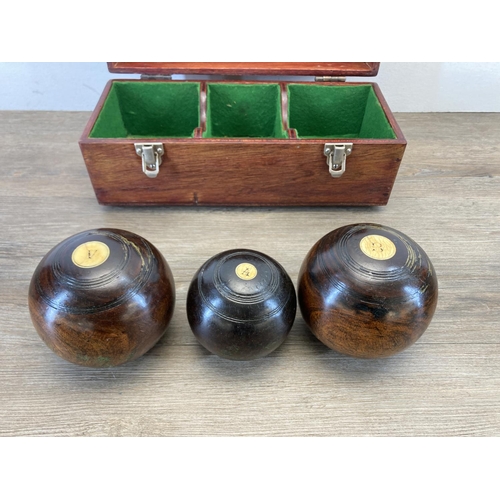 471 - A pair of late 19th/early 20th century Lignum Vitae crown green bowls with jack and wooden case