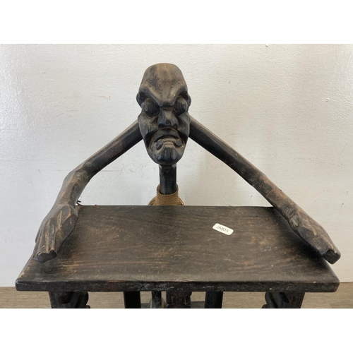 521 - An African carved hardwood figural CD rack - approx. 60cm high