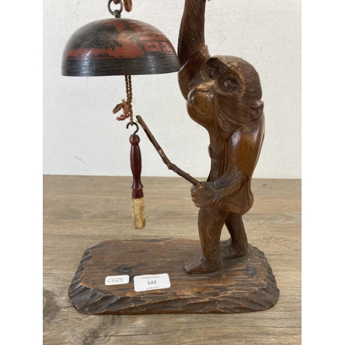 522 - A Chinese carved hardwood monkey figurine with metal hanging bells - approx. 48cm high