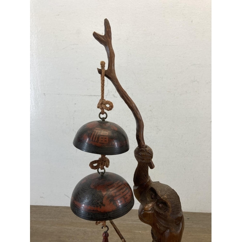 522 - A Chinese carved hardwood monkey figurine with metal hanging bells - approx. 48cm high