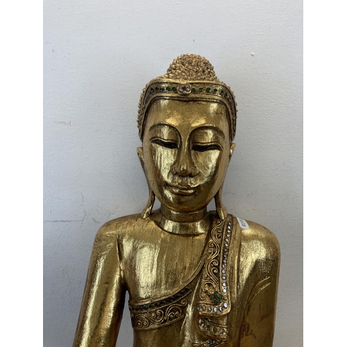 524 - A modern gilt plaster buddha statue - approx. 62cm high