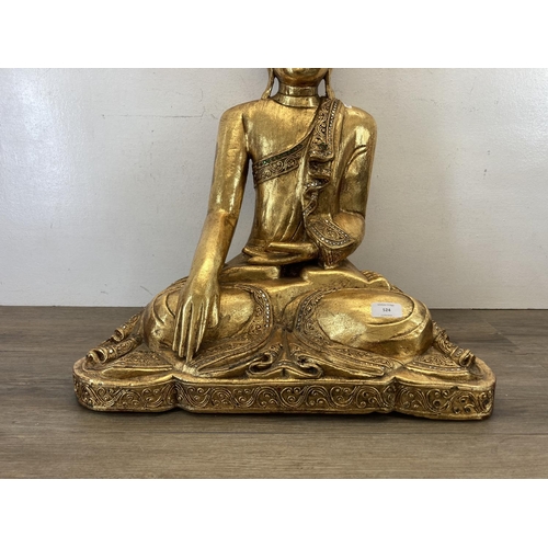 524 - A modern gilt plaster buddha statue - approx. 62cm high