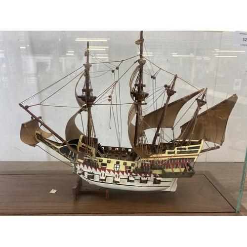 525 - A hand painted wooden model ship with glass case and oak plinth - approx. 35cm high x 20cm wide x 58... 