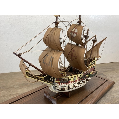 525 - A hand painted wooden model ship with glass case and oak plinth - approx. 35cm high x 20cm wide x 58... 