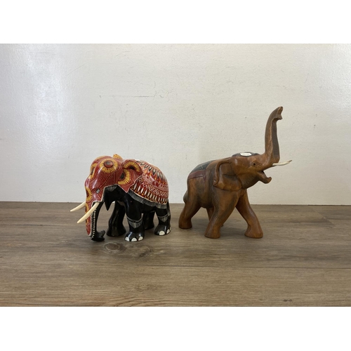 556 - Two hand painted and carved wooden elephant figurines - largest approx. 33cm high