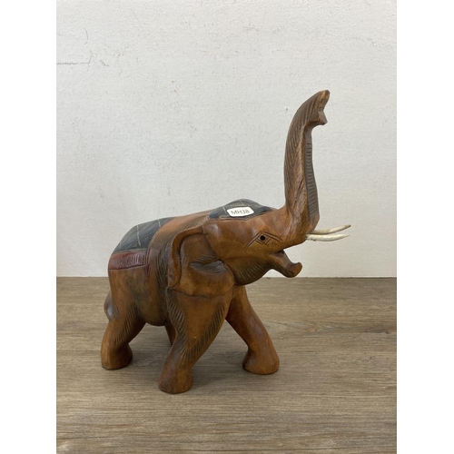 556 - Two hand painted and carved wooden elephant figurines - largest approx. 33cm high