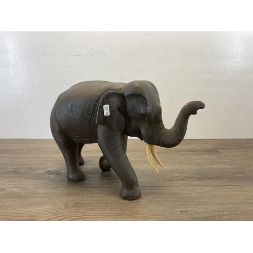 557 - A carved hardwood elephant figurine - approx. 28cm high