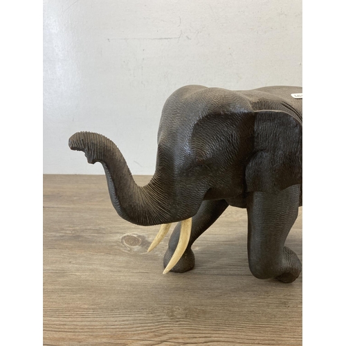 557 - A carved hardwood elephant figurine - approx. 28cm high