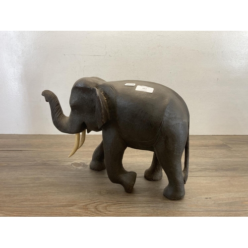 557 - A carved hardwood elephant figurine - approx. 28cm high