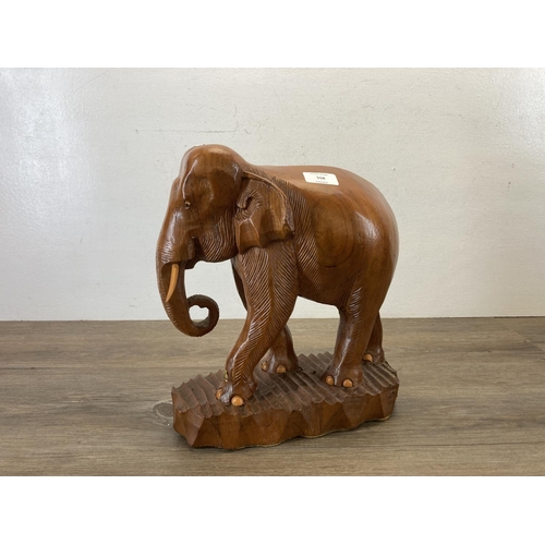 558 - A carved teak elephant figurine - approx. 34cm high