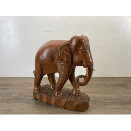 558 - A carved teak elephant figurine - approx. 34cm high