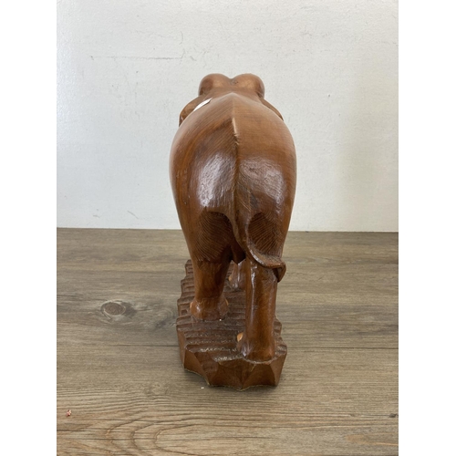 558 - A carved teak elephant figurine - approx. 34cm high