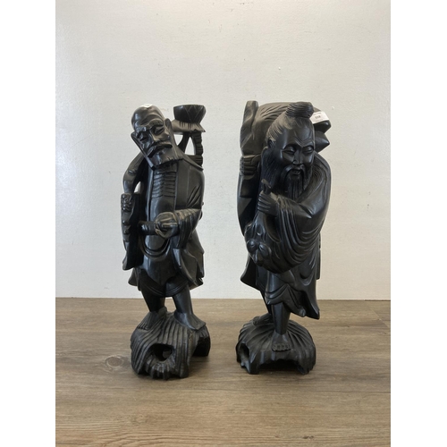 559 - Two Oriental carved hardwood figurines - approx. 51cm high