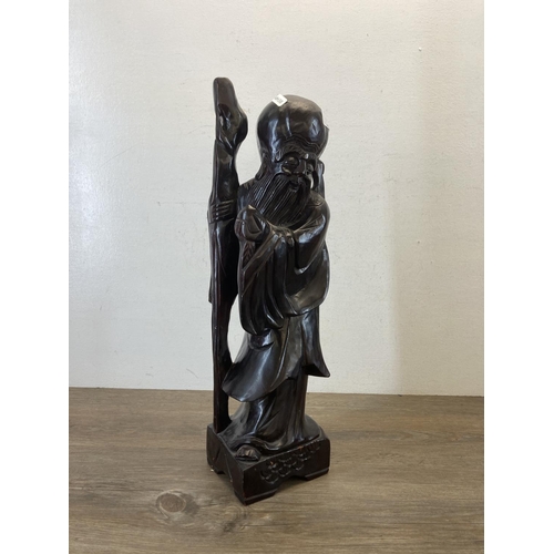 560 - An Oriental carved hardwood figurine - approx. 51cm high