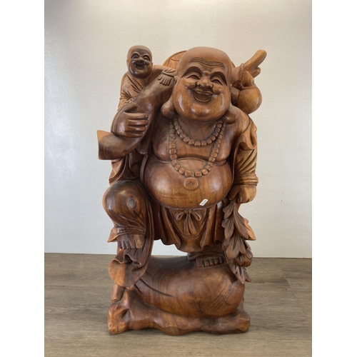 563 - An Oriental carved hardwood laughing buddha statue - approx. 82cm high