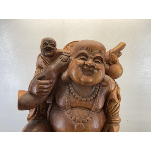 563 - An Oriental carved hardwood laughing buddha statue - approx. 82cm high