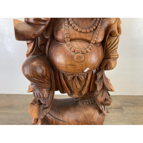 563 - An Oriental carved hardwood laughing buddha statue - approx. 82cm high