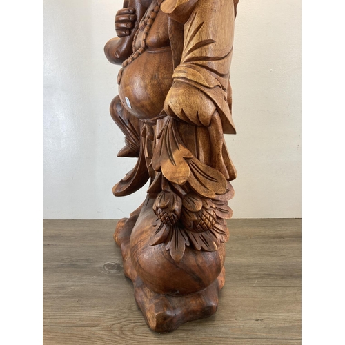 563 - An Oriental carved hardwood laughing buddha statue - approx. 82cm high