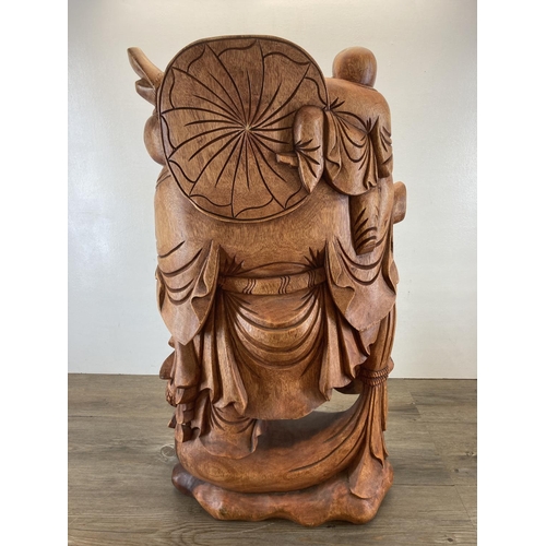 563 - An Oriental carved hardwood laughing buddha statue - approx. 82cm high