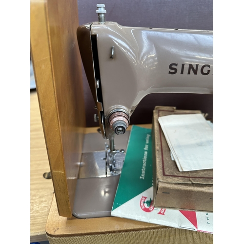 752 - A cased Singer 185K electric sewing machine with boxed attachments and instruction manual