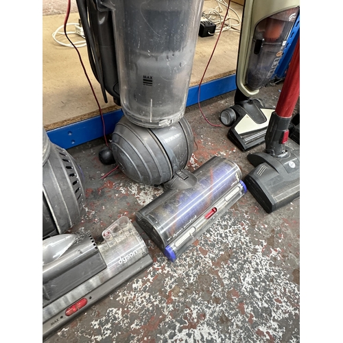 763 - Three Dyson upright bagless vacuum cleaners to include DC41, DC25 etc.